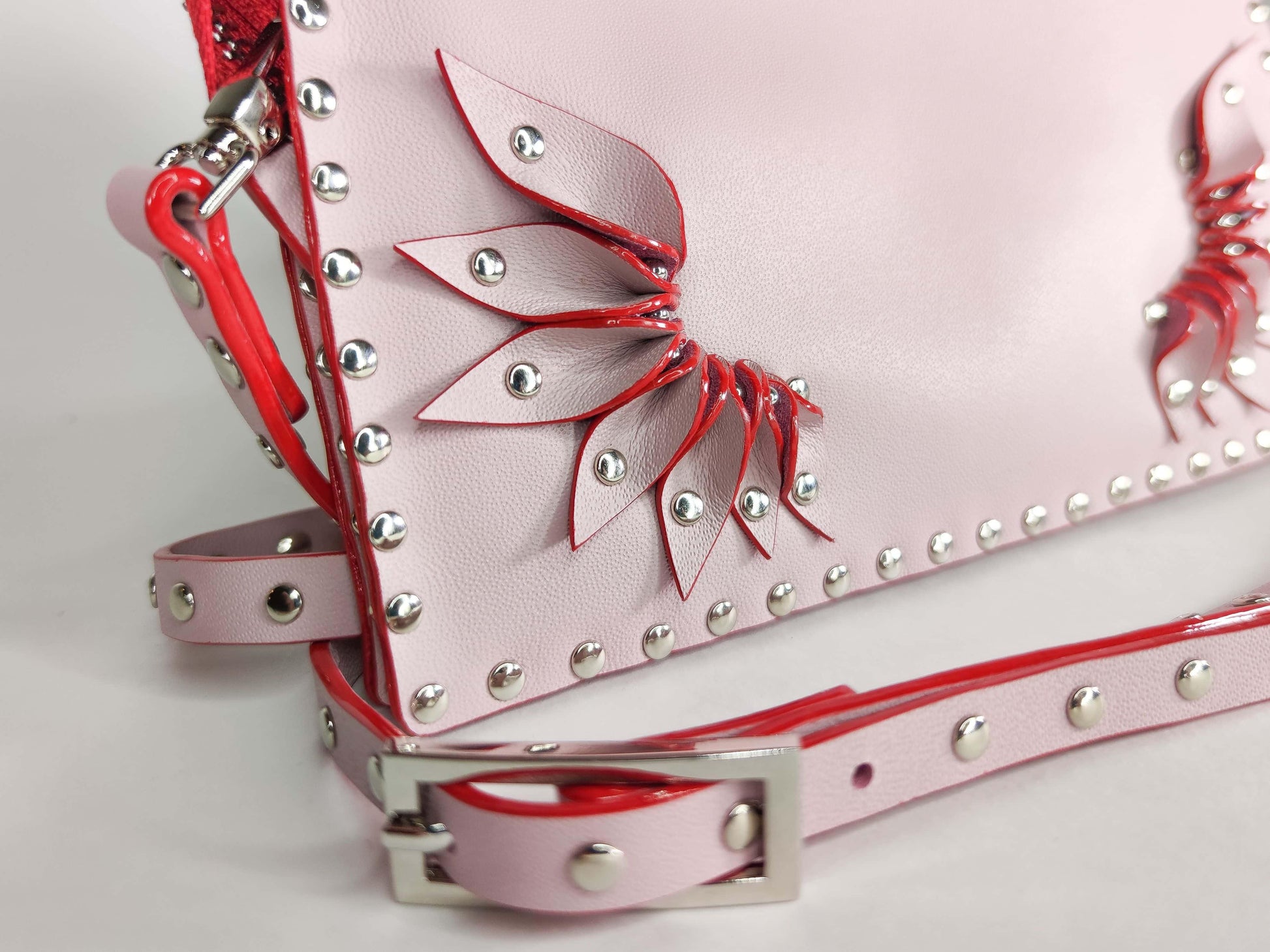 Exquisite detail of Clutch Bag With Wings and Rivets showcasing the fine craftsmanship and elegant design characteristic of Axinia Collection 's luxury collection.